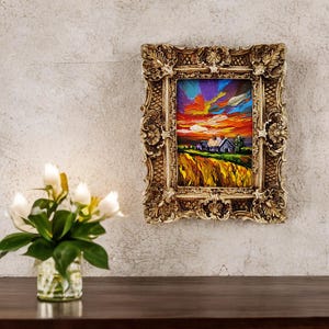 May include: An ornate, gold-colored framed painting depicting a vibrant sunset over a rural landscape. The artwork features a farmhouse, fields of yellow, and a colorful sky with hues of orange, purple, and blue. The frame has detailed scrollwork.