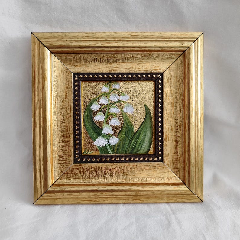 Peut inclure: Peinture carr&eacute;e encadr&eacute;e de fleurs de muguet. L'&oelig;uvre pr&eacute;sente des fleurs blanches en forme de clochettes et des feuilles vertes sur un fond dor&eacute;. Le cadre dor&eacute;, &agrave; l'aspect textur&eacute;, ajoute une touche d'&eacute;l&eacute;gance &agrave; cette &oelig;uvre florale.