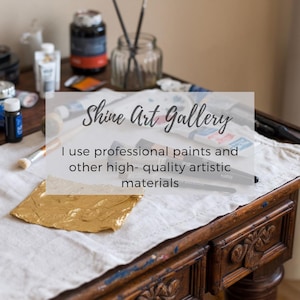 May include: A still life of art supplies on a wooden table. The image features paint tubes, brushes, and a jar of paintbrushes. The text overlay reads "Shine Art Gallery" and "I use professional paints and other high-quality artistic materials."