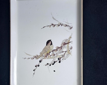 May include: Rectangular white tray with a gold trim, featuring a painted illustration of a bird perched on a flowering branch. The bird has brown and yellow feathers. The tray is likely used for serving or display.