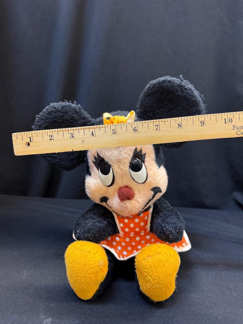 Puede incluir: Un peluche vintage de Minnie Mouse con orejas negras, un vestido de lunares rojos y blancos y pies amarillos. El juguete mide aproximadamente 15 cm de altura.