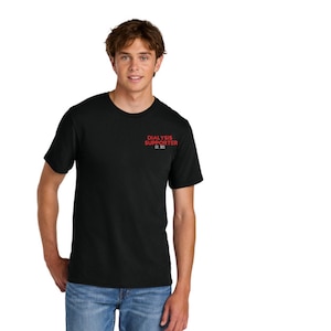 Puede incluir: Camiseta negra con el texto rojo "DIALYSIS SUPPORTER EST. 1975" en la parte superior izquierda del pecho. La camiseta es de manga corta y está hecha de un material suave. La persona lleva vaqueros azules.