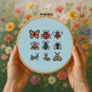 May include: A cross-stitch embroidery hoop featuring various insect designs, including a butterfly, ladybug, and bee, on a light blue background. The hoop is held by hands against a backdrop of colorful flowers. The embroidery is in a pixelated style.