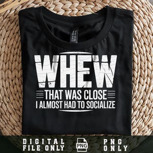 以下が含まれることがあります： 白い文字で「WHEW THAT WAS CLOSE I ALMOST HAD TO SOCIALIZE」と書かれた黒いTシャツ。シャツは織られた表面に折りたたまれています。画像の下部には「DIGITAL FILE ONLY PNG ONLY」と書かれています。