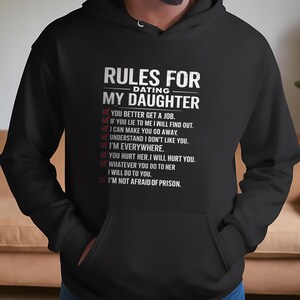 May include: Black hoodie with white text that reads "Rules for Dating My Daughter" and a list of rules for dating the wearer's daughter.