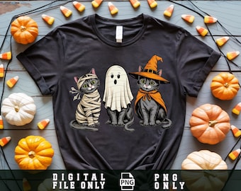 May include: Dark gray t-shirt featuring three cartoon cats dressed for Halloween. One cat is wrapped in bandages, another is a ghost, and the third wears a witch hat and cape. The words "DIGITAL FILE ONLY" and "PNG ONLY" are printed at the bottom.