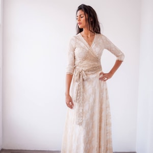 Woman looking at the left and with the hand in the waist wearing a boho wedding dress with sleeves