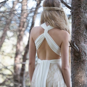 Bride in the woods with a wedding dress tied at her back. It's a relaxed rustic bridal gown that can be worn in many different ways as it's convertible