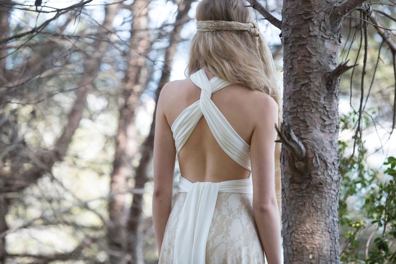 Bride in the woods with a wedding dress tied at her back. It's a relaxed rustic bridal gown that can be worn in many different ways as it's convertible