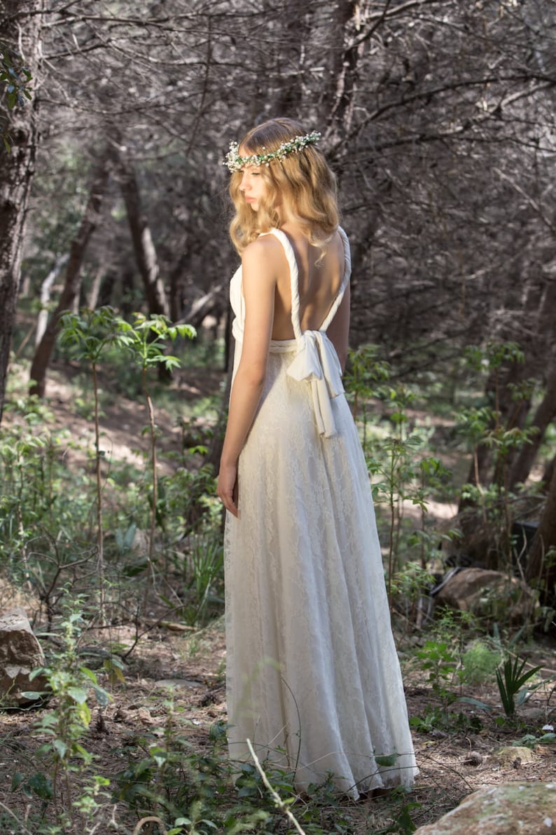 Beautiful bride in the nature wearing a convertible wedding dress. In this photo she is showing her back. Thanks to the multiway design, she can choose how much skin she shows or hides, adapting it to her body and style