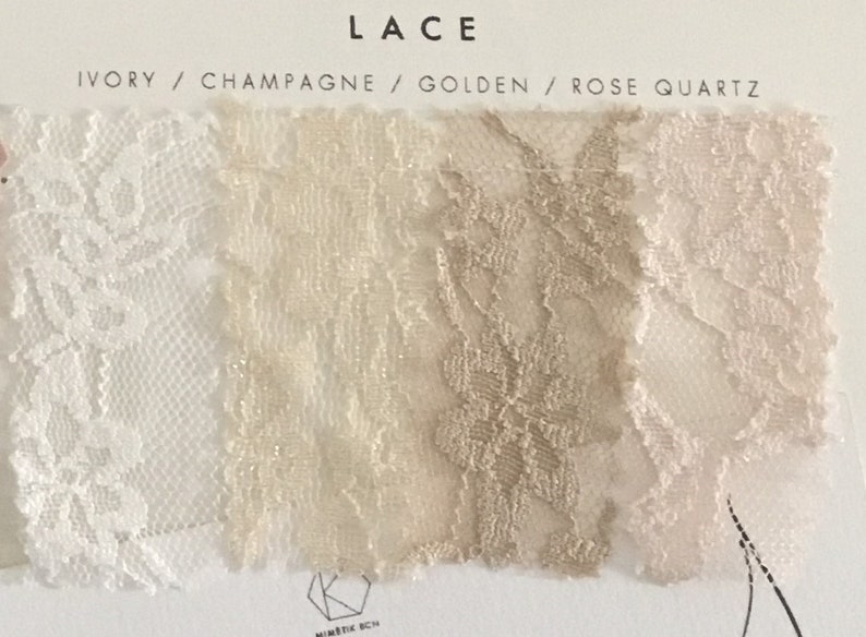 May include: A fabric swatch card labeled LACE with four color options: Ivory, Champagne, Golden, and Rose Quartz. Each section displays a distinct floral lace pattern in its respective color, arranged horizontally on a white background.