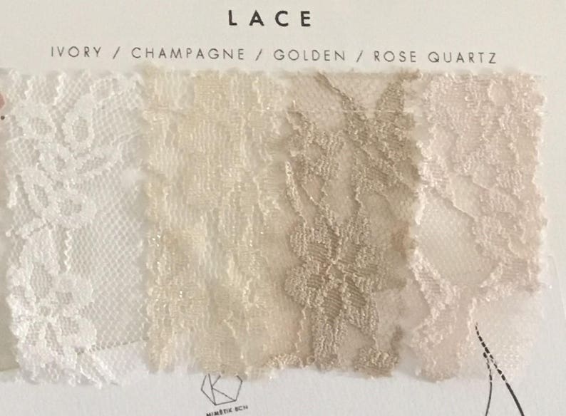 May include: A fabric swatch card labeled LACE with four color samples: Ivory, Champagne, Golden, and Rose Quartz. Each section displays a distinct floral lace pattern in its respective hue, arranged horizontally on a white background.