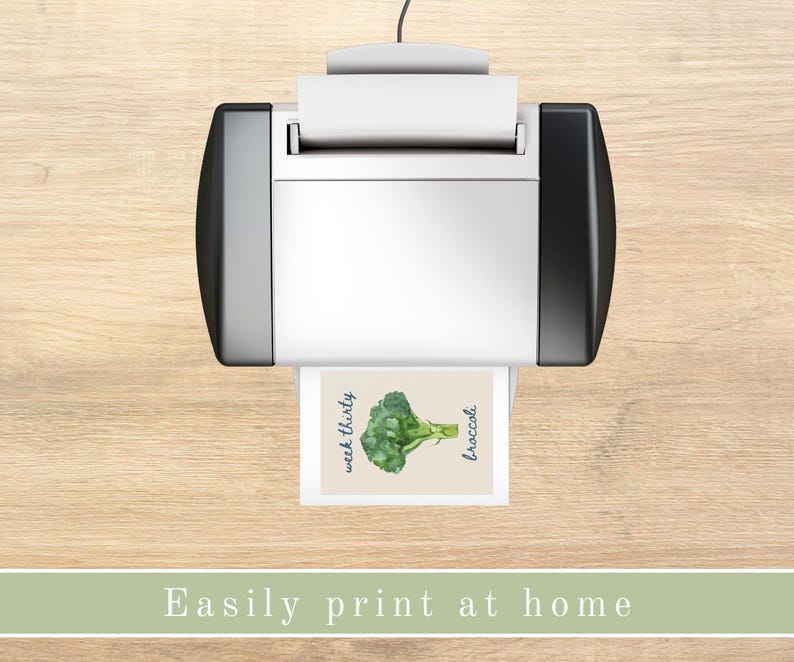 K&ouml;nnte beinhalten: Ein wei&szlig;er Drucker mit einer schwarzen Seitenwand druckt eine Karte mit einer Aquarell-Illustration eines gr&uuml;nen Brokkolis und dem Text "week thirty broccoli".