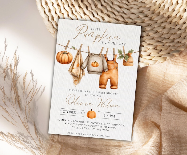 May include: A baby shower invitation with a watercolor design. The invitation features the text "A Little Pumpkin is on the Way." The design includes illustrations of a pumpkin, baby clothes, and a hat hanging on a clothesline. The invitation is for Olivia Wilson's baby shower on October 15th.