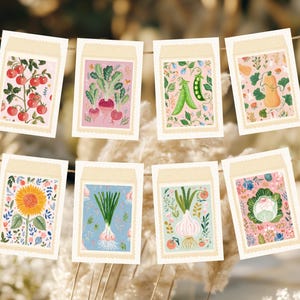Puede incluir: Una colección de ocho ilustraciones de sobres de semillas, cada una con una verdura o flor diferente. Los sobres están dispuestos en una cuerda, mostrando diseños coloridos de tomates, rábanos, guisantes, una calabaza, un girasol, cebollas y col.