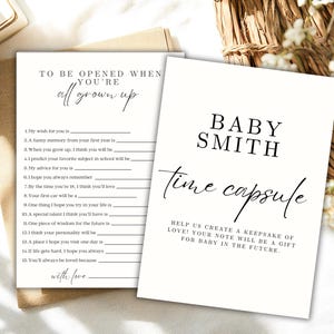 Könnte beinhalten: Zwei weiße Karten mit schwarzem Text. Auf der einen steht "Zu öffnen, wenn du erwachsen bist" mit Ausfüllaufforderungen. Auf der anderen steht "Baby Smith Zeitkapsel" mit einer Nachricht über die Erstellung eines Andenkens.