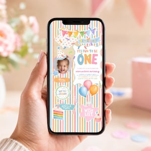 May include: A smartphone displaying a digital first birthday invitation with a pastel rainbow striped background. The design features a photo of a child, colorful balloons, a cake, and text that reads It's Fun To Be One, Olivia's First Birthday.