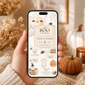 Puede incluir: Un smartphone que muestra una invitación digital para un baby shower con temática de Halloween. El diseño incluye fantasmas, calabazas, una telaraña y el texto a little BOO is almost due, Olivia Smith, sobre un fondo de pergamino.