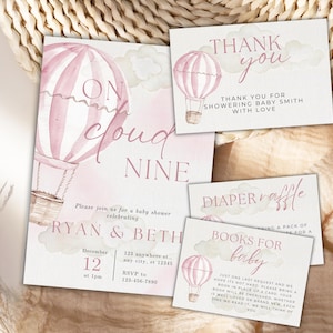 May include: A set of baby shower stationery with a hot air balloon theme. The invitation reads "On Cloud Nine" and includes details for the event. Additional cards say "Thank You", "Diaper Raffle", and "Books for Baby". The color scheme is soft pink and white.