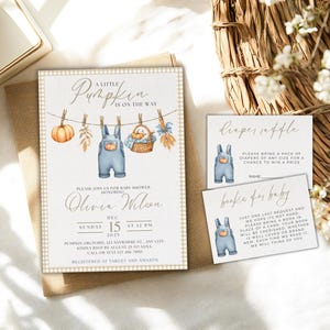 May include: Baby shower invitation with a pumpkin theme. The invitation features a watercolor illustration of dungarees, a pumpkin, and a basket. The text reads "A Little Pumpkin is on the Way." Includes diaper raffle and book for baby cards.
