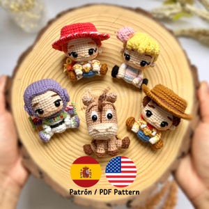 Puede incluir: Cinco pequeñas muñecas de ganchillo con grandes ojos negros y trajes detallados, incluyendo un sombrero rojo, pelo amarillo, tocado morado, un caballo marrón y un sombrero marrón. El texto Patrón / PDF Pattern aparece impreso abajo.