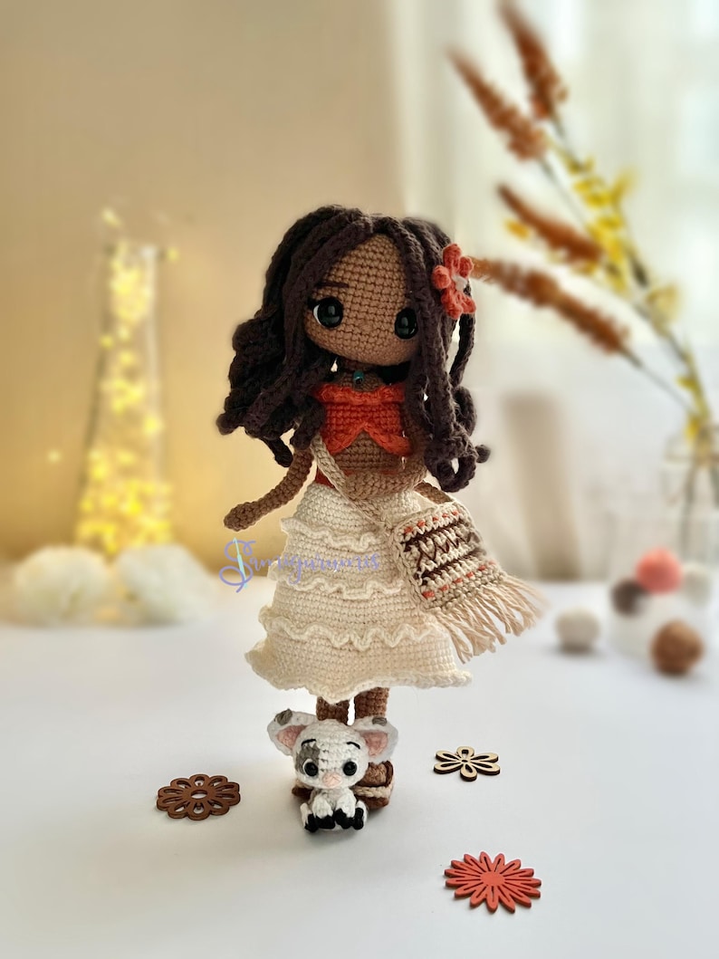 May include: A crocheted doll with brown hair, a white dress, and a brown and orange bag. The doll is holding a small crocheted pig.