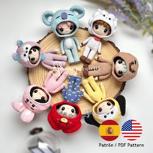 Op de afbeelding: Een verzameling van acht kleine gehaakte poppen, elk met een capuchon met dierenthema. De poppen hebben verschillende kleuren, waaronder lichtblauw, wit, roze, geel, rood en bruin. De tekst Patrón / PDF Pattern is zichtbaar.