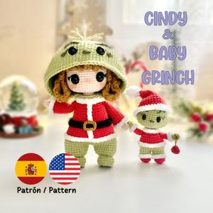 Puede incluir: Se muestran dos muñecos de ganchillo, Cindy y Baby Grinch. Cindy viste un atuendo rojo y blanco con cinturón negro y capucha verde. Baby Grinch lleva un atuendo similar y un gorro de Papá Noel. El texto "Cindy & Baby Grinch" es visible.