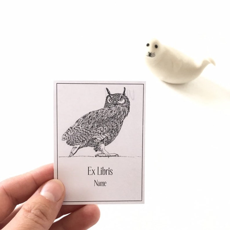 Puede incluir: Una ilustraci&oacute;n en blanco y negro de un b&uacute;ho en una tarjeta blanca con el texto "Ex Libris" y "Nombre".