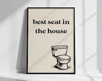 May include: Black framed art print with the text "best seat in the house" above a black and white illustration of a toilet. The artwork is displayed against a neutral background.