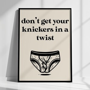 May include: A framed print with the phrase "don't get your knickers in a twist" in black text. Below the text is a black and white illustration of underwear. The background is a light beige color.