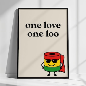 May include: A framed art print with the words "one love one loo" in black font. Below the text is a cartoon toilet paper roll wearing sunglasses and a cape in red, yellow, and green.