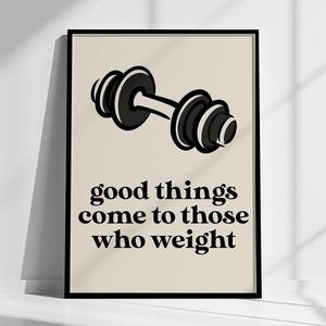 May include: A framed print featuring a black and white dumbbell illustration on a beige background. The text reads "good things come to those who weight". A motivational piece of art for a home gym or fitness area.