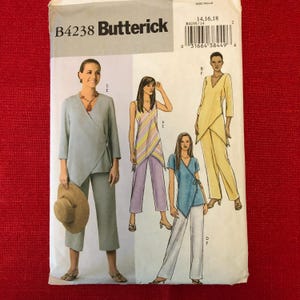 May include: A sewing pattern for women's clothing, featuring three different styles of tops and pants. The pattern is from Butterick and has the number B4238 on it. The pattern is for sizes 14, 16, and 18.