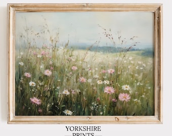 May include: A framed painting of a field of wildflowers with pink and white flowers. The painting is in a light wood frame and has a soft, dreamy feel.