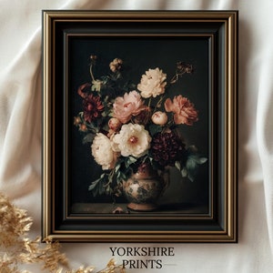 Puede incluir: Impresión floral enmarcada que presenta una naturaleza muerta de flores en un jarrón decorativo. La obra de arte muestra un ramo de flores rosas, blancas y burdeos sobre un fondo oscuro. El marco es negro con un borde interior dorado. El texto "YORKSHIRE PRINTS" está en la parte inferior.