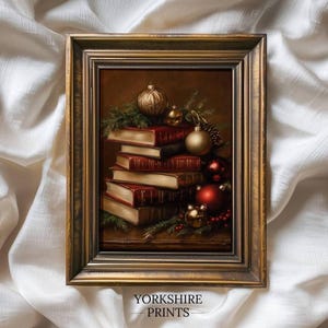 May include: A framed print titled Yorkshire Prints featuring a stack of vintage books in red and cream bindings, adorned with gold and red Christmas ornaments, pine branches, and small red berries, all enclosed in an ornate dark gold frame.