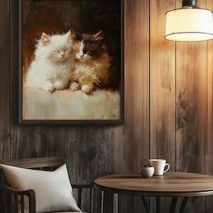 May include: A painting of two white and brown cats sleeping next to each other. The cats are in a soft, cozy setting and their eyes are closed. The painting is framed in a dark wood frame.