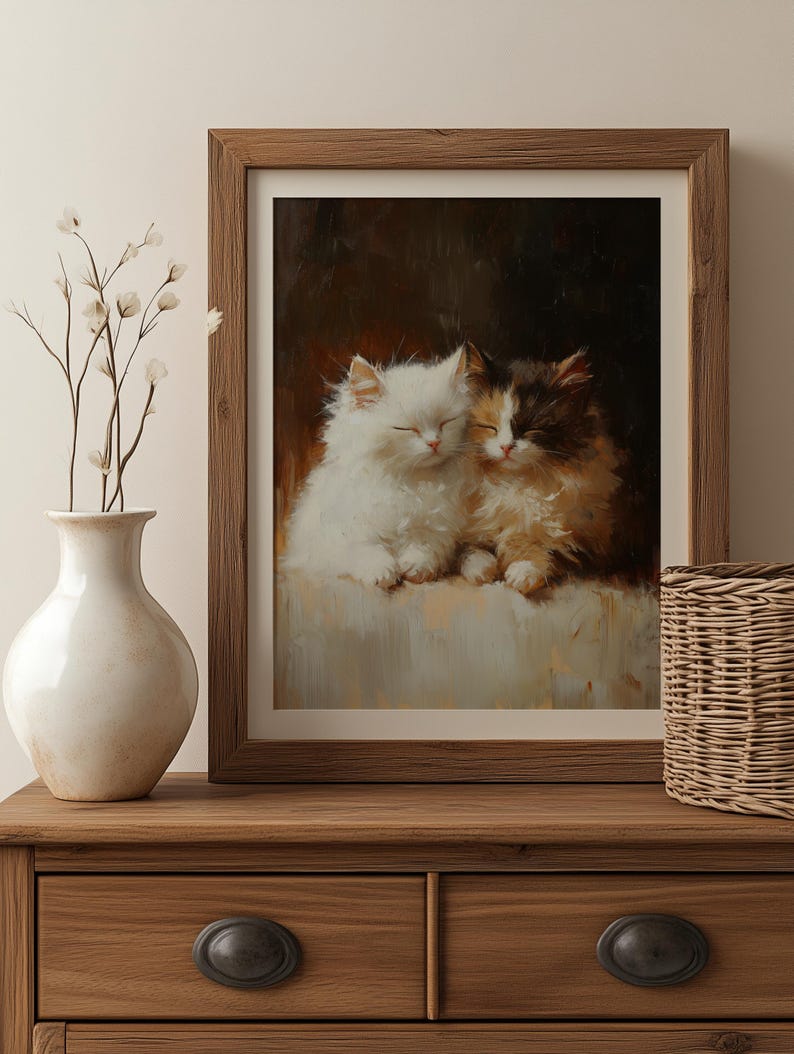 May include: A framed painting of two white and brown kittens cuddling together. The kittens are sleeping with their eyes closed. The painting is set against a dark brown background.