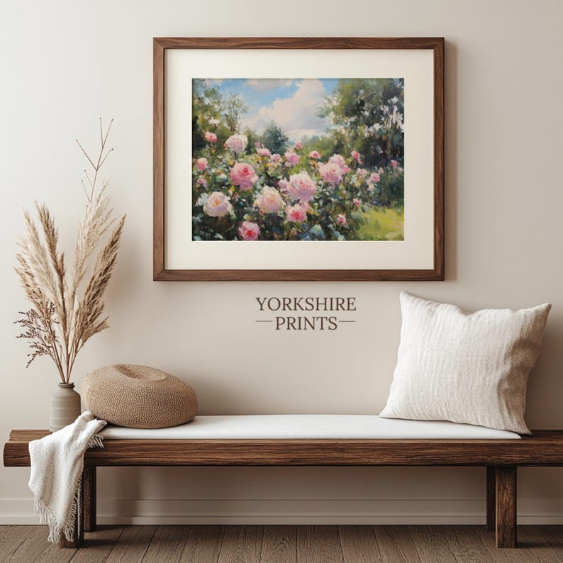 Puede incluir: Una pintura enmarcada de un jard&iacute;n con rosas rosadas en flor. La pintura est&aacute; en un marco marr&oacute;n y est&aacute; colgada en una pared blanca. La pared tambi&eacute;n est&aacute; decorada con un arreglo de hierba seca en un jarr&oacute;n.