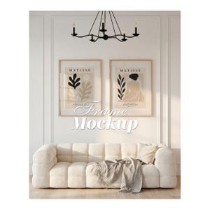 May include: Two rectangular wall art prints in light wood frames featuring Matisse-inspired abstract botanical and figure illustrations in black and beige. The prints are displayed above a cream-colored tufted sofa with a textured throw blanket.