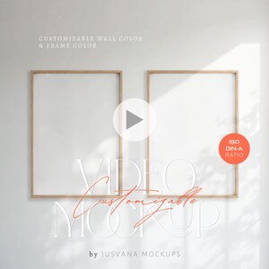 Puede incluir: Dos marcos de fotos vacíos con bordes de madera clara se muestran en una pared blanca. El texto "VIDEO customizable MOCKUP" está superpuesto en una fuente estilizada. El texto adicional incluye "CUSTOMIZABLE WALL COLOR & FRAME COLOR" y "by JUSVANA MOCKUPS". Un círculo naranja dice "ISO DIN-A RATIO".