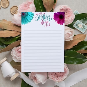 May include: A white lined notepad with the text "Happy Mother's Day" in blue and pink lettering. The notepad is surrounded by pink roses and green leaves.