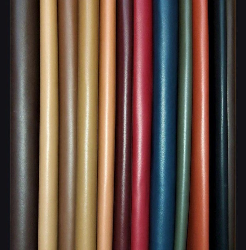 May include: A variety of leather strips in different colors, including brown, tan, red, blue, and green. The strips are arranged side by side, showing the different textures and shades of the leather.