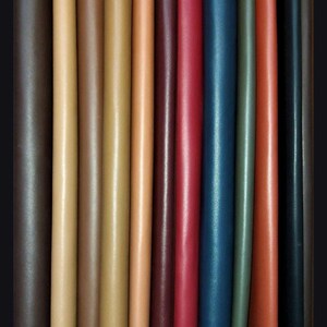 Puede incluir: Una variedad de tiras de cuero en diferentes colores, incluyendo marr&oacute;n, beige, rojo, azul y verde. Las tiras est&aacute;n dispuestas una al lado de la otra, mostrando las diferentes texturas y tonos del cuero.