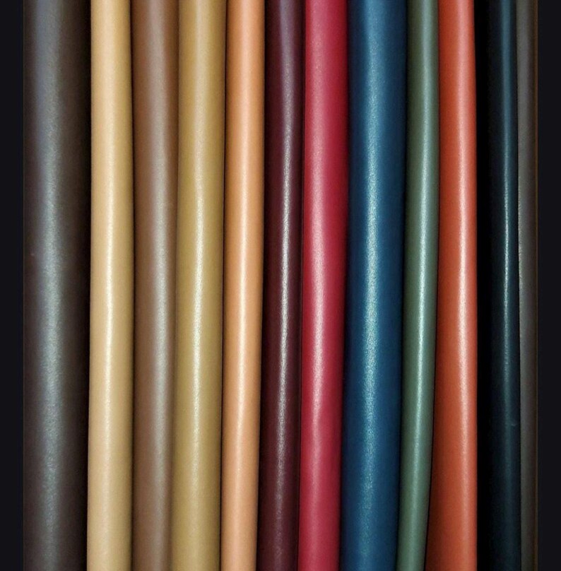 Puede incluir: Una variedad de tiras de cuero en diferentes colores, incluyendo marr&oacute;n, beige, rojo, azul y verde. Las tiras est&aacute;n dispuestas una al lado de la otra, mostrando las diferentes texturas y tonos del cuero.