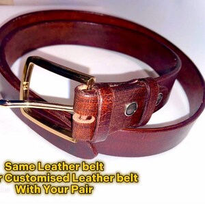Puede incluir: Un cintur&oacute;n de cuero marr&oacute;n con una hebilla dorada. El cintur&oacute;n est&aacute; doblado por la mitad y la hebilla es visible. El texto "Same Leather belt Order Customised Leather belt With Your Pair" es visible debajo del cintur&oacute;n.