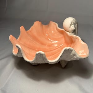 Puede incluir: Un juego de tres tazas de cerámica con un acabado moteado y mate. Las tazas son en tonos crema, gris claro y gris oscuro. Cada taza tiene un diseño simple y minimalista, perfecto para café o té.