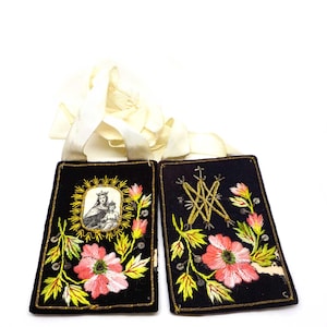 May include: Two black embroidered religious patches with floral and religious imagery. One patch features a framed image of a woman and child, the other has a starburst design. Both have pink and yellow flowers and gold trim.