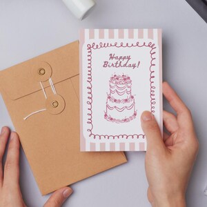 Puede incluir: Una taza de cer&aacute;mica blanca con un asa negra y el texto "But First, Coffee" en negro, con una fuente de estilo manuscrito. La taza est&aacute; sobre una superficie blanca.